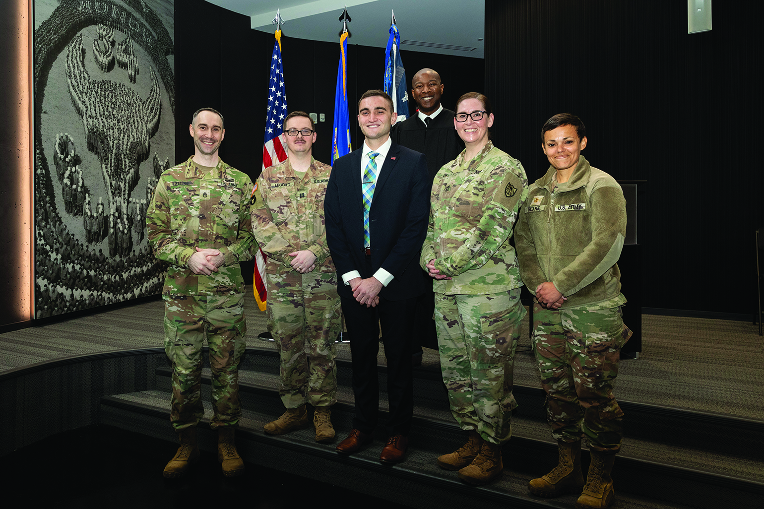 SGT Dylan Moser (center), a paralegal spe
            -
            cialist with Headquarters Support Company,
            34th Red Bull Infantry Division, Minnesota
            National Guard, stands with members of the
            Minnesota National Guard’s legal team at the
            General John W. Vessey Readiness Center
            on 13 November 2023. SGT Moser recently
            graduated law school and passed the bar
            exam. (Credit: SSG Mahsima Alkamooneh)